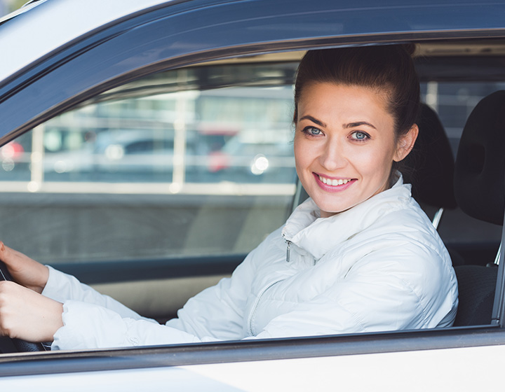 woman in her new car with the Cheapest Car Insurance in Moore