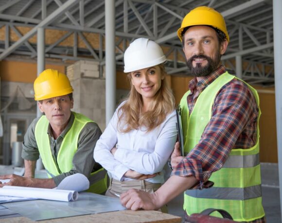 Two Males and 1 Female Contractors Smiling at Camera in Construction Site with Contractors Insurance in Oklahoma City